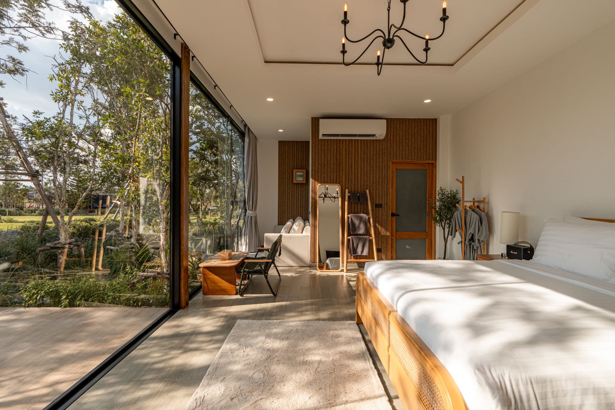 Glass villa bedroom with garden view