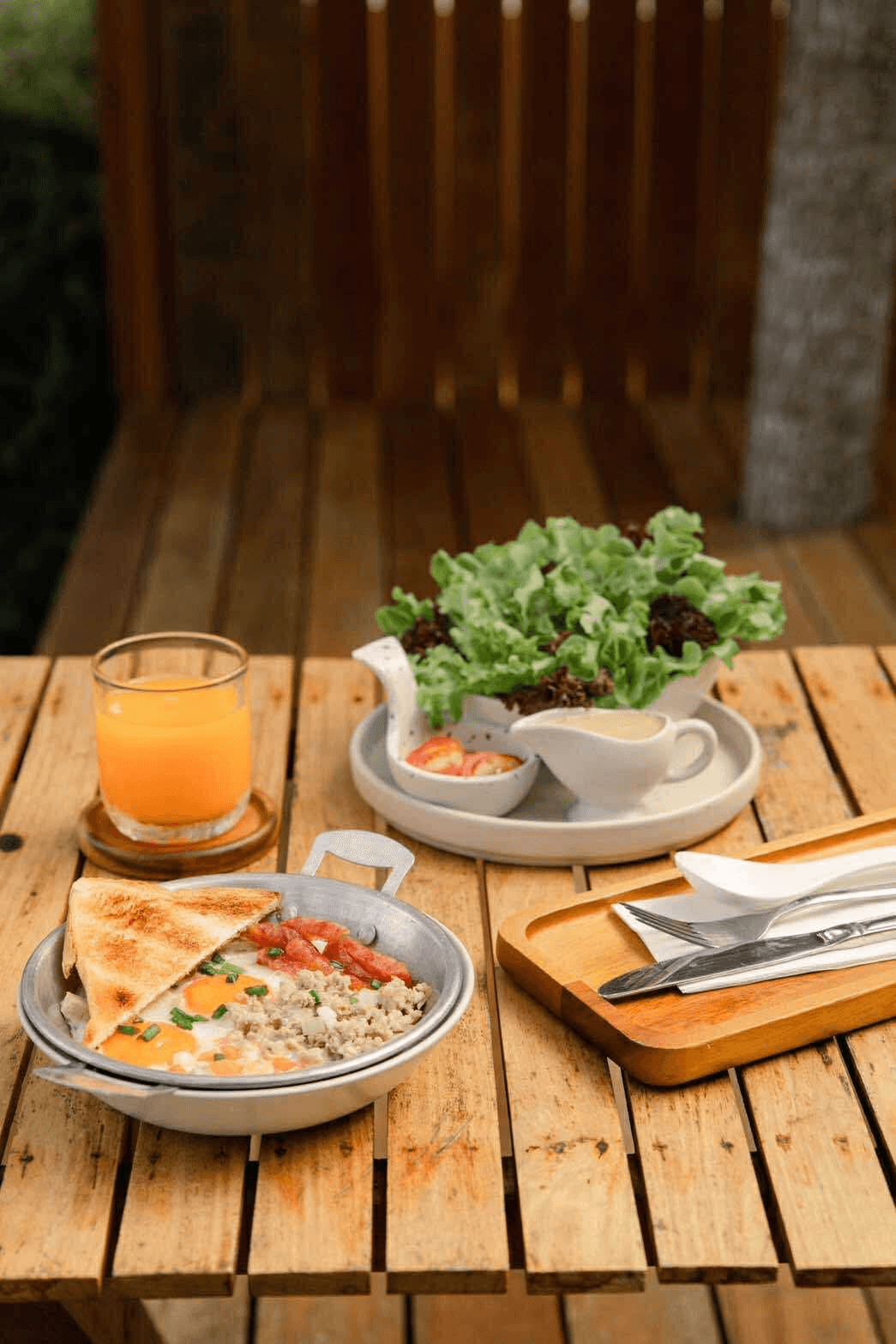 Skillet eggs with toast, sausage, orange juice and fresh salad