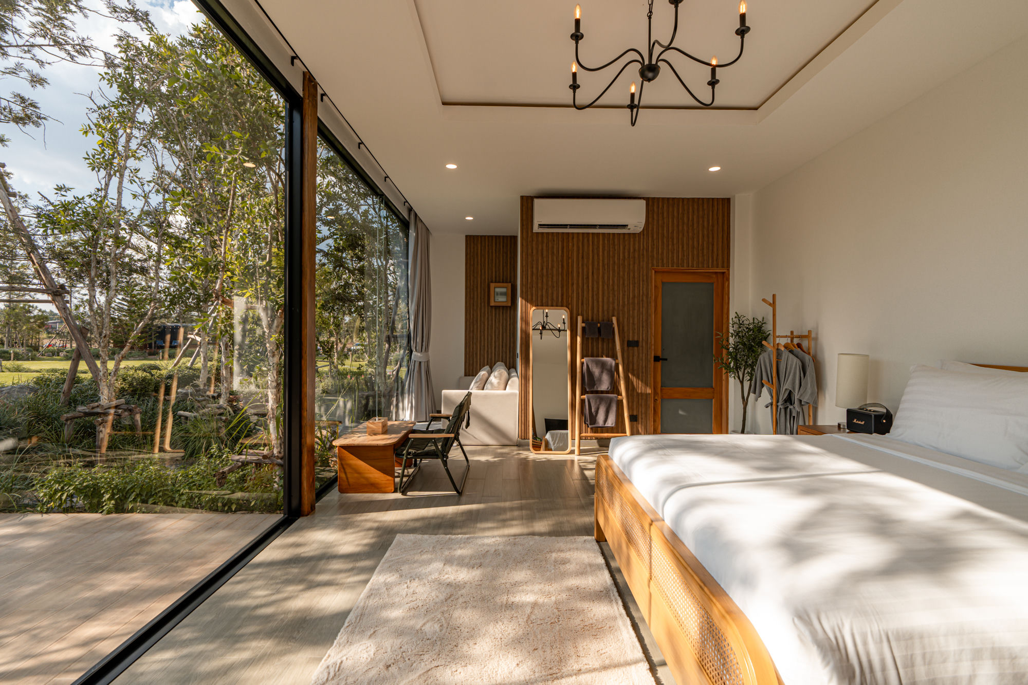 Glass villa bedroom with garden view