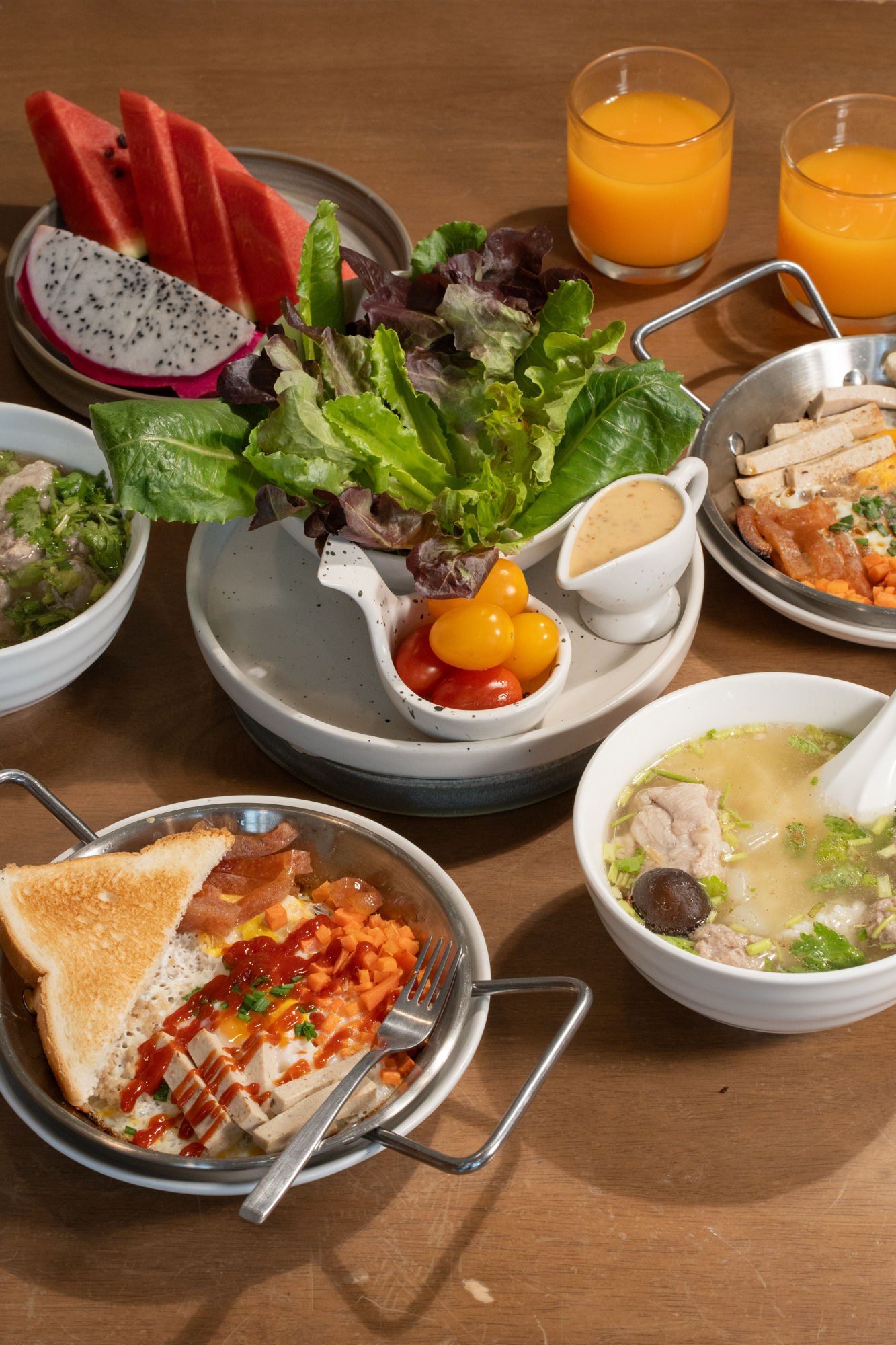Full breakfast spread — pan eggs, salad, soup and orange juice