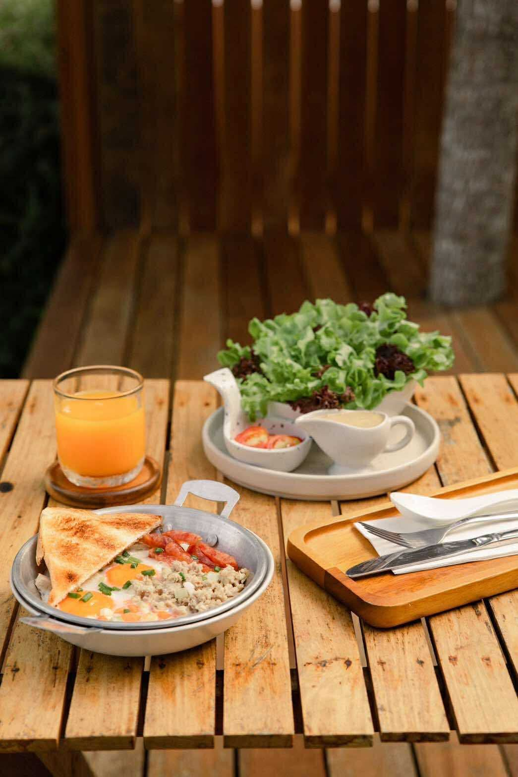 Skillet eggs with toast, sausage, orange juice and fresh salad