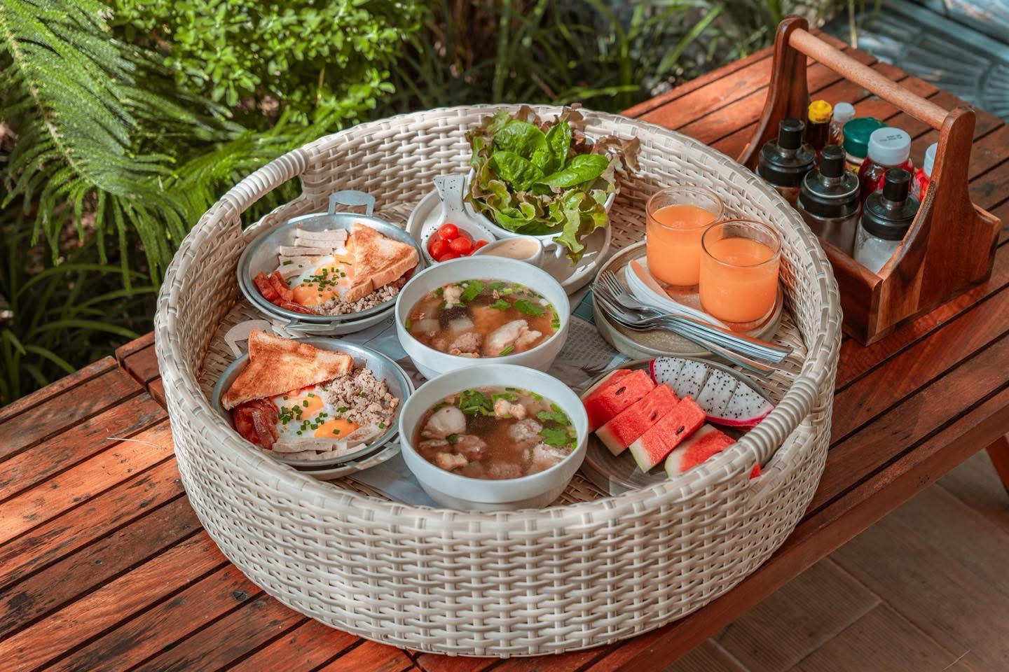 Rattan breakfast basket — skillet eggs, rice soup, fruits and fresh juice