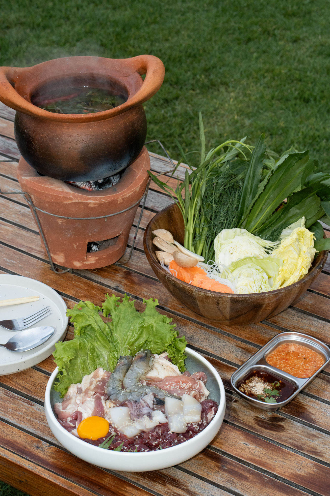 Charcoal clay-pot moo krata being cooked outdoors
